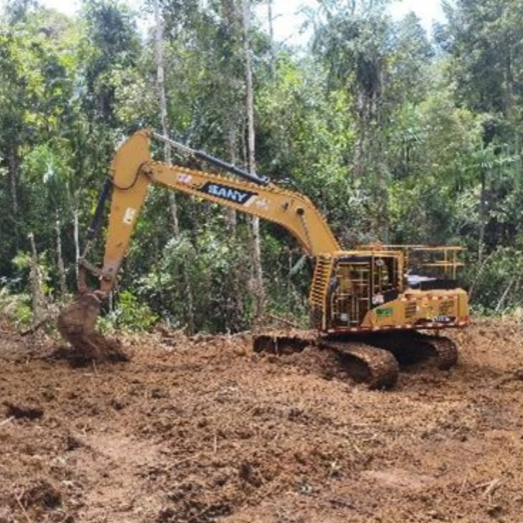 Excavator sedang mempersiapkan drill pad untuk kegiatan pengeboran geoteknik di area hutan Sulawesi.
