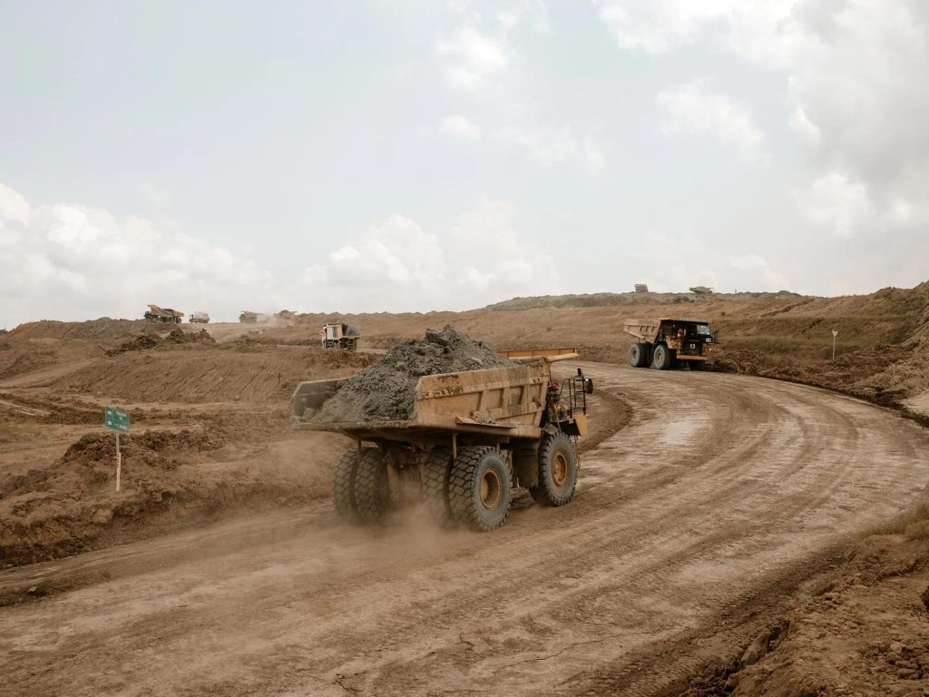 Jalan tambang dengan dump truck hauling yang memerlukan pengujian CPTu untuk analisis daya dukung tanah dan desain haul road pertambangan.